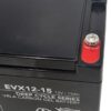 Der obere Teil einer Landport Gel-Batterie des Typs EVX12-15 ist zu sehen. Das Gehäuse ist schwarz, die Batterie hat eine rechteckige Form. Auf der Oberseite befinden sich zwei Anschlussklemmen, eine davon ist mit einer roten Kunststoffabdeckung versehen. Die weiße Beschriftung auf der Vorderseite nennt den Typ, die Spannung von 12 Volt und die Kapazität von 15 Amperestunden. Weitere technische Angaben und Warnsymbole sind ebenfalls aufgedruckt.
